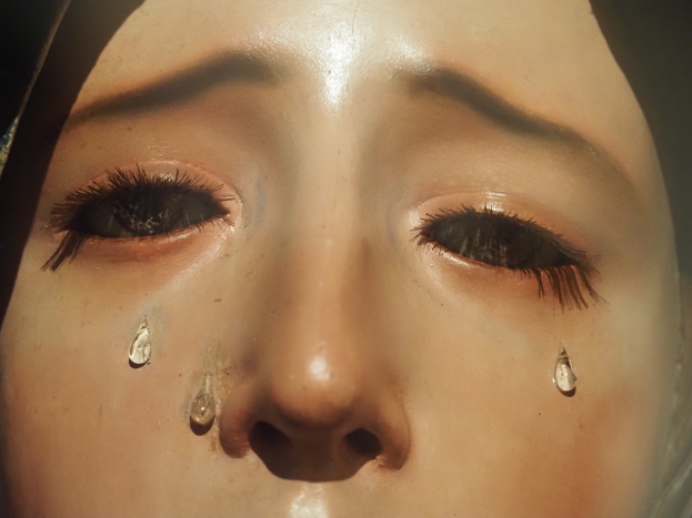 Eine Frau mit Tränen im Gesicht, deren Gesichtsausdruck Trauer und Verzweiflung ausdrückt.