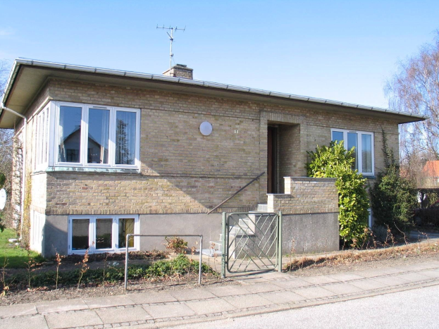 Zweizimmer-Doppelhaushälter zum Verkauf in St Johns Wood, Swindon, mit Dach, Fenstern, Tür, Treppe, Metallzaun, Pflanzen, Gras, Bäumen, Satellitenschälte und bewölktem Himmel.