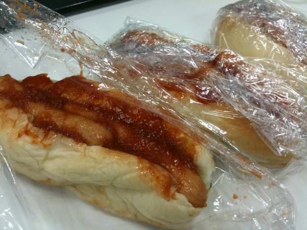 Ein Tisch mit Sandwiches, Hot Dogs und Ketchup in der Mitte.