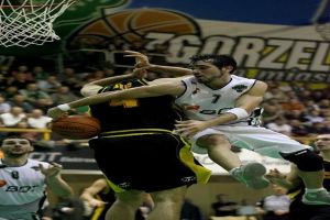 Eine Gruppe von Männern spielt Basketball vor Zuschauern, mit einem Netz und einer Fahne im Hintergrund.