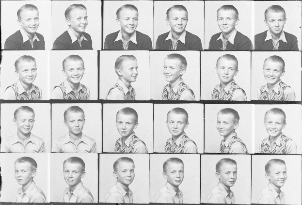 Ein Schwarz-Weiß-Foto eines strahlenden jungen Jungen mit ordentlich gekämmtem Haar, hellen Augen und einem glücklichen Gesichtsausdruck.