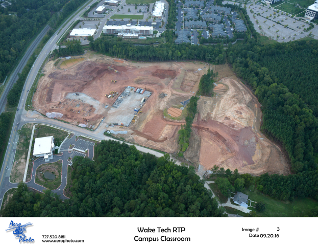 Luftaufnahme des Wake Tech RTP Campus Classroom mit sichtbaren Bäumen, Gebäuden, Straßen, Fahrzeugen und Text mit einem Logo unten.