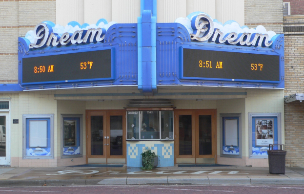 Außenansicht des Dream Theaters in St. Louis, Missouri, mit Glastüren und -fenstern, einem Namen Schild, einem Müllbehälter, einem Topf mit einer Pflanze und einer Straße im Vordergrund.