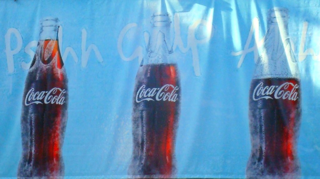 Drei Coca-Cola-Flaschen auf einem Tuch gedruckt.