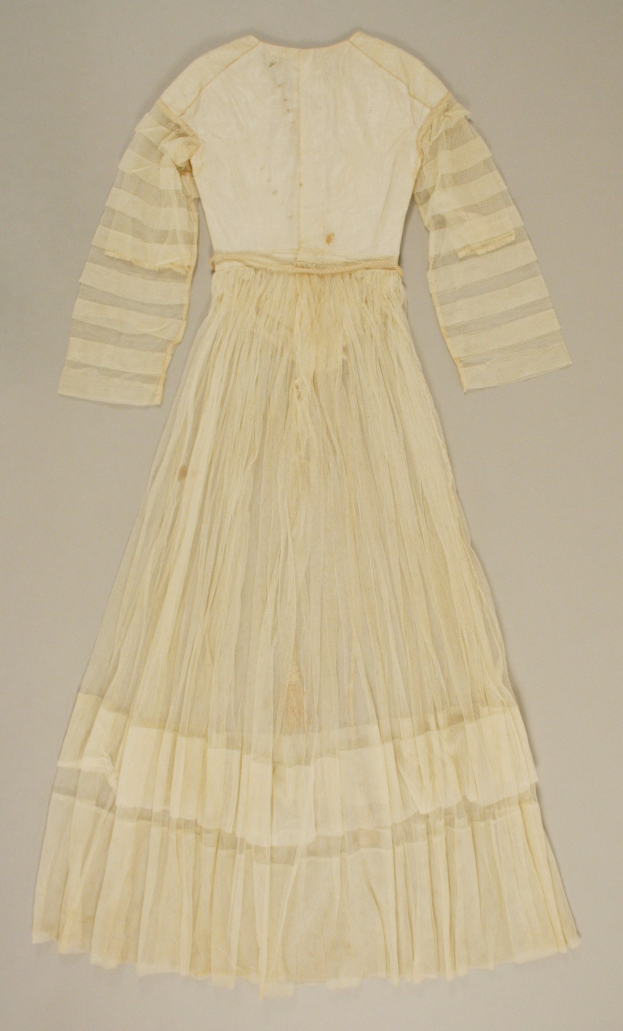 Ein weißes, langärmeliges Kleid mit einer gerüschten, bodenlangen Schleppe und hohem Bund auf einem weißen Hintergrund, das aus einem leichten, luftigen Stoff mit einem dezenten Schimmer besteht.