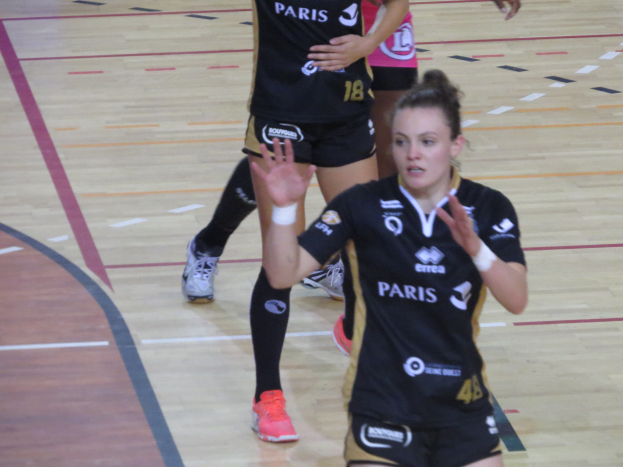 Eine Gruppe von Frauen in Sportkleidung beim Volleyballspielen auf einem Court.