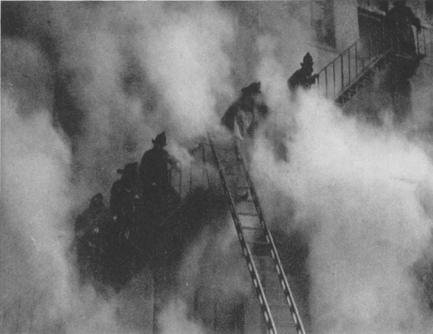 Schwarz-weißes Bild von Feuerwehrleuten auf einer Leiter vor einem raucherfüllten Gebäude mit Text unten.