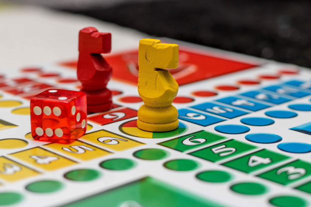 Ein Monopoly-Brettspiel mit zwei roten und gelben Würfeln auf einem unscharfen Hintergrund.