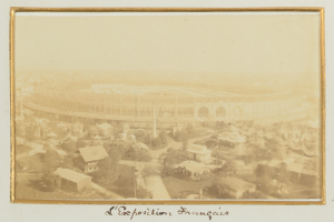 Altes Foto eines Stadions in städtischer Umgebung mit umliegenden Gebäuden, Bäumen und Masten, mit Text unten.