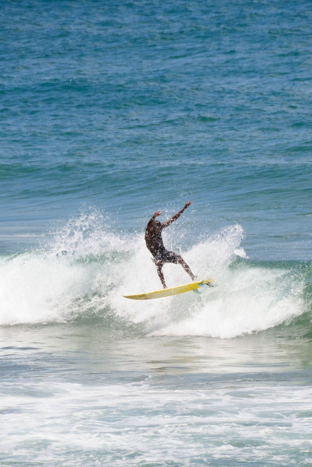 Mann surft auf einer Welle im Wasser